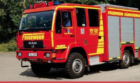 Rotes Löschgruppenfahrzeug von MAN mit Rolltoren an der Seite und der Aufschrift „Feuerwehr Dänischenhagen“.