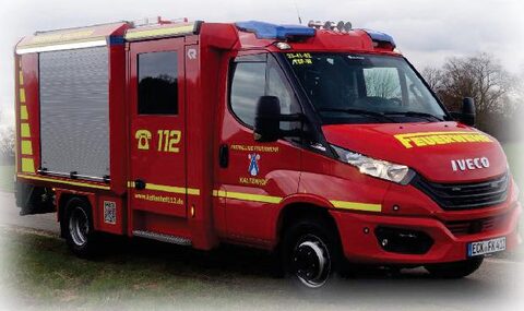 Rotes Feuerwehrfahrzeug von Iveco mit gelben Streifen, Rolltor an der Seite, Blaulicht und der Notrufnummer 112 an der Tür.