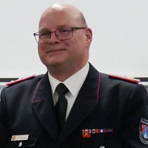 Porträt von Marc-Oliver Haßlberger in dunkelblauer Feuerwehr-Uniform mit Krawatte.